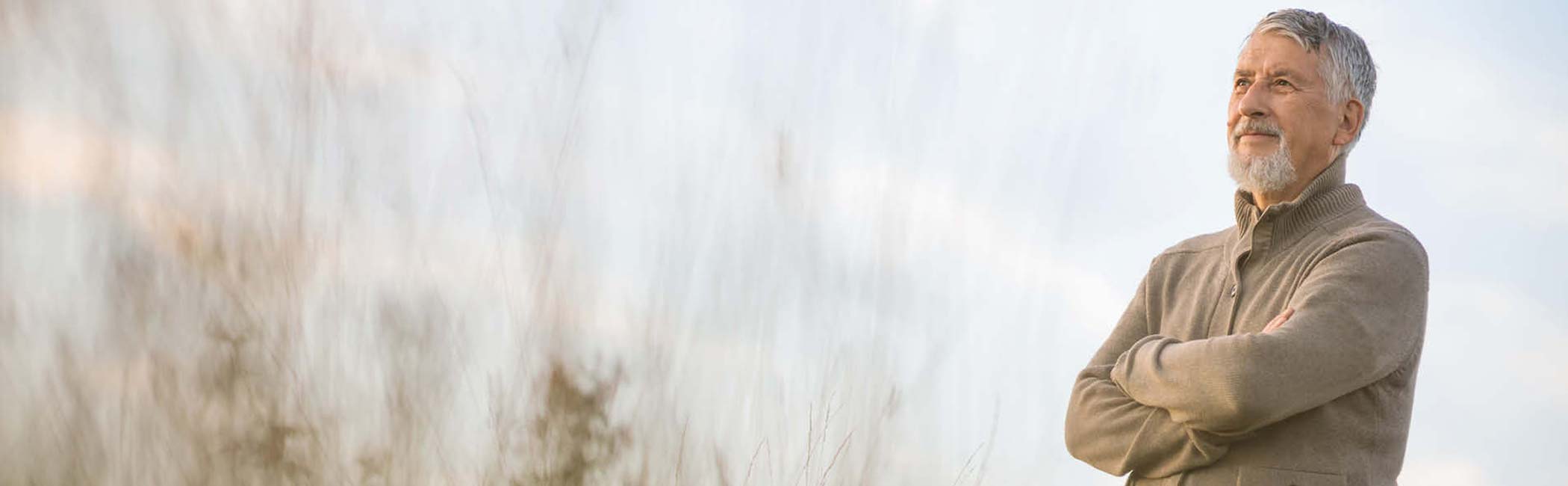 En mand står eftertænksomt og kigger ud.